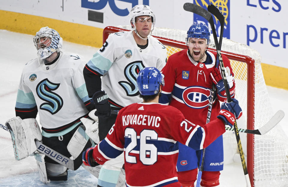 Montreal Canadiens' Tanner Pearson (70) celebrates after his goal with teammate Johnathan Kovacevic (26) as Seattle Kraken goaltender Philipp Grubauer, left, and defender Brian Dumoulin (8) react during second-period NHL hockey game action in Montreal, Monday, Dec. 4, 2023. (Graham Hughes/The Canadian Press via AP)