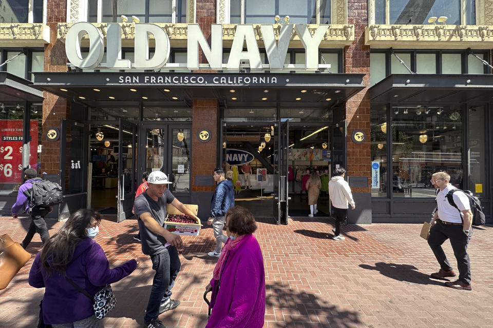 People make their way past the entrance to the flagship Old Navy store which is closing later this year in San Francisco, on June 21, 2023. San Francisco's downtown has seen an exodus of retailers and now a shopping mall owner is turning the complex over to its lender in the face of declining foot traffic and empty office space. While San Francisco faces some of its own unique issues, such as a heavy reliance on tech workers, most of them working largely remotely, the problems serve as warning signs for other downtowns across the country, which are also feeling some pain. (AP Photo/Eric Risberg)