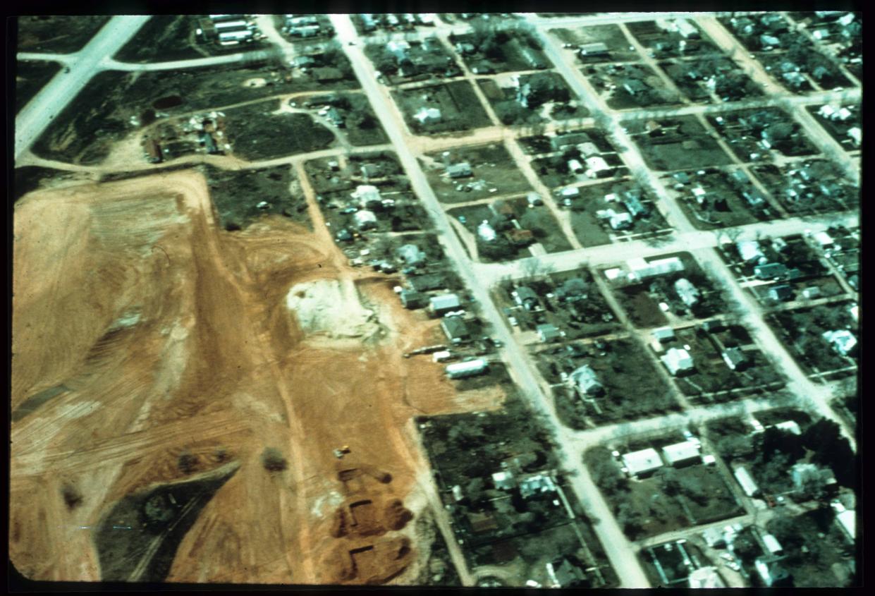 An overhead photo of a neighborhood with a large patch of dirt