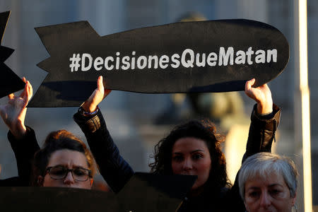 FILE PHOTO: People hold placards reading "Decisions that kill"during a gathering to demand a halt of arm sales to Saudi outside Parliament in Madrid, Spain, October 24, 2018. REUTERS/Paul Hanna/File Photo