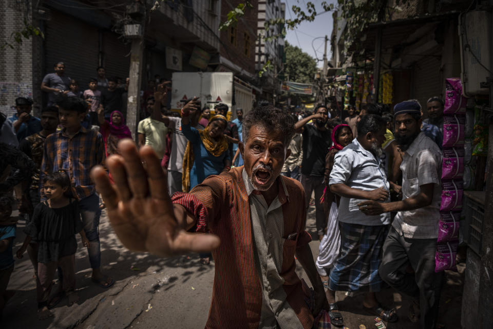 Un musulmán furioso les dice a los periodistas que se vayan, alegando que distorsionan los hechos, mientras tiendas propiedad de musulmanes son demolidas en el vecindario de Jahangirpuri, en el noroeste de Nueva Delhi, el 20 de abril de 2022, días después de que la capital de la India fue presa de hechos de violencia durante una procesión hindú. Autoridades con bulldozers demolieron varias tiendas hasta que la Corte Suprema del país les ordenó que se detuvieran. (AP Foto/Altaf Qadri)