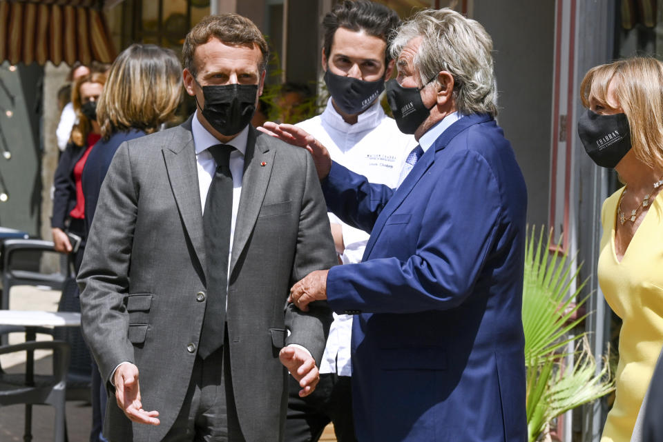 French President Emmanuel Macron, left, talks with restaurant owner Michel Chabran as he arrives for a lunch Tuesday June 8, 2021 in Valence, southeastern France. French President Emmanuel Macron has been slapped in the face by a man during a visit in a small town of southeastern France, Macron's office confirmed. (Philippe Desmazes, Pool via AP)