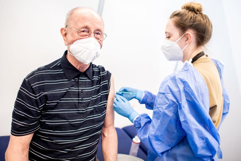 Heinrich Atoni recibe una dosis de la vacuna de Pfizer-BioNTech en el centro de vacunación instalado en el recinto ferial de Bremen, noroeste de Alemania, el 26 de febrero de 2021