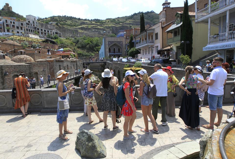 A soup of Russian tourists listen to a guide in The Old Town of Tbilisi, Russia, Saturday, June 22, 2019. Kremlin spokesman Dmitry Peskov noted that thousands of Russian tourists vacationing were in Georgia, as a reason of Moscow's concern about what he described as an anti-Russian "provocation." (AP Photo/Shakh Aivazov)