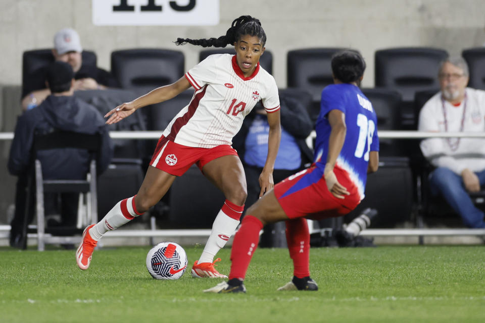 Canada's Ashley Lawrence, left, tries to dribble around United States' Crystal Dunn during the second half of a SheBelieves Cup women's soccer match Tuesday, April 9, 2024, in Columbus, Ohio. (AP Photo/Jay LaPrete)