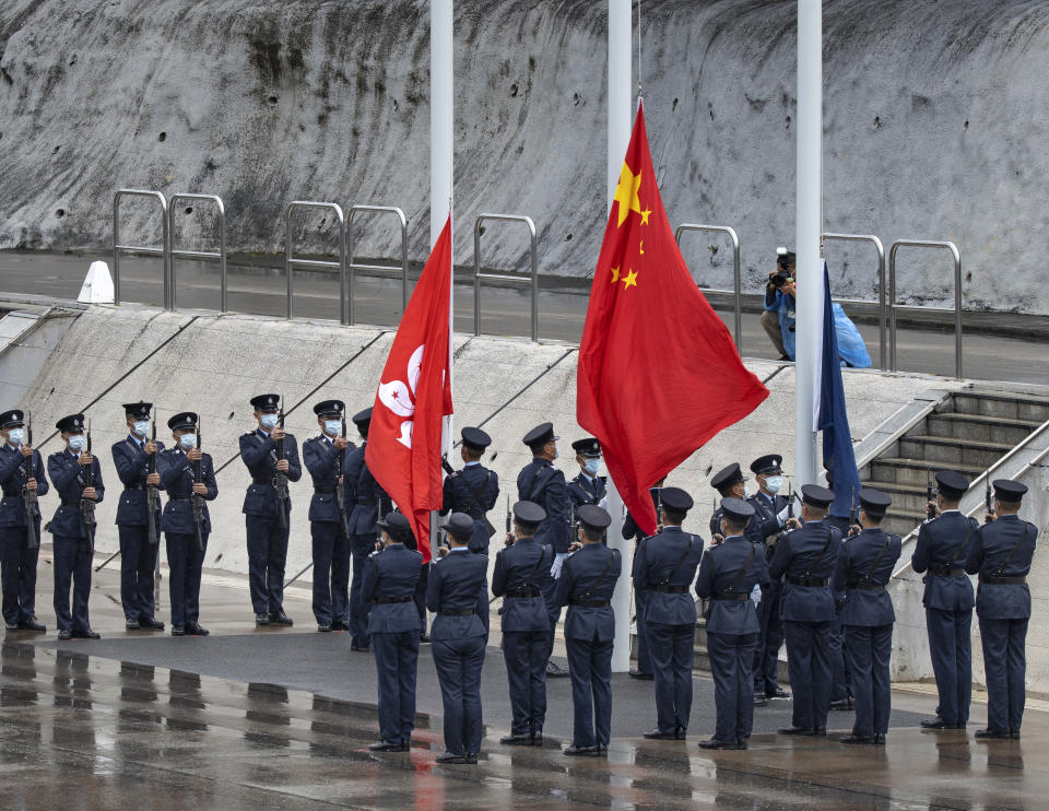 Hong Kong police officers attend a flag raising ceremony on the National Security Education Day at a police school in Hong Kong Thursday, April 15, 2021. Authorities marked the event with a police college open house, where police personnel demonstrated the Chinese military’s goose step march, replacing British-style foot drills from the time Hong Kong was ruled by the U.K. until the 1997 handover to China.(AP Photo/Vincent Yu)