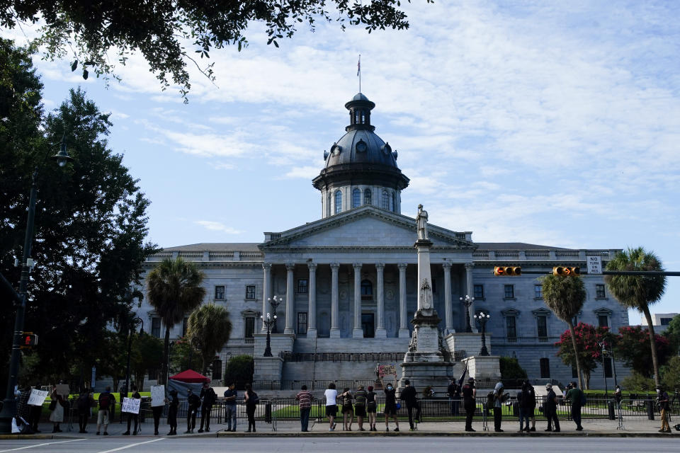 Demonstrators protest in front of a Confederate statue at the State House Friday, July 10, 2020, in Columbia, S.C. Demonstrators gathered for the five year anniversary after the Confederate battle flag was removed from the State House grounds after a two-thirds vote by the Legislature. (AP Photo/Chris Carlson)