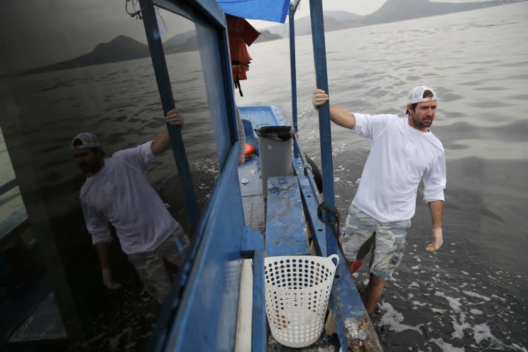 Brad Funk helps clean up Guanabara Bay. (REUTERS)