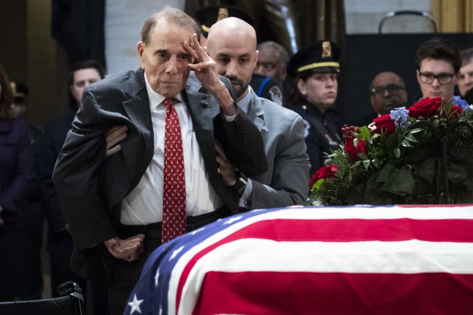 18) Bob Dole salutes the late president's casket.