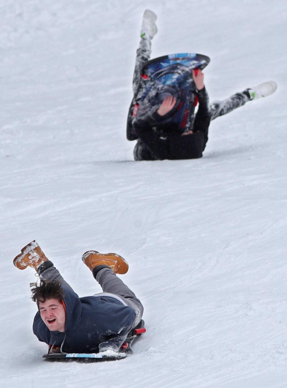 Gauge Franklin stays on his sled as a friend wipes out at Goodyear Heights Metro Park sledding hill in Akron in this file photo.
