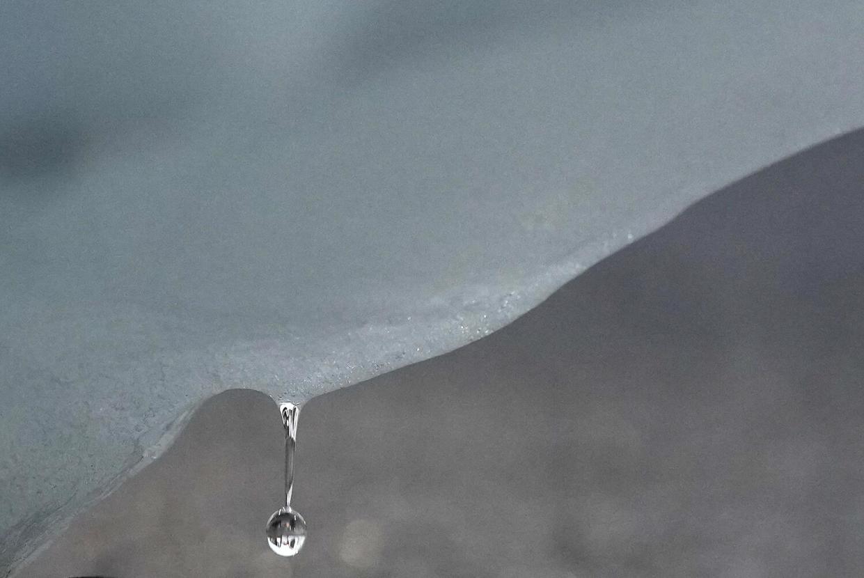 A droplet of water falls from an iceberg.