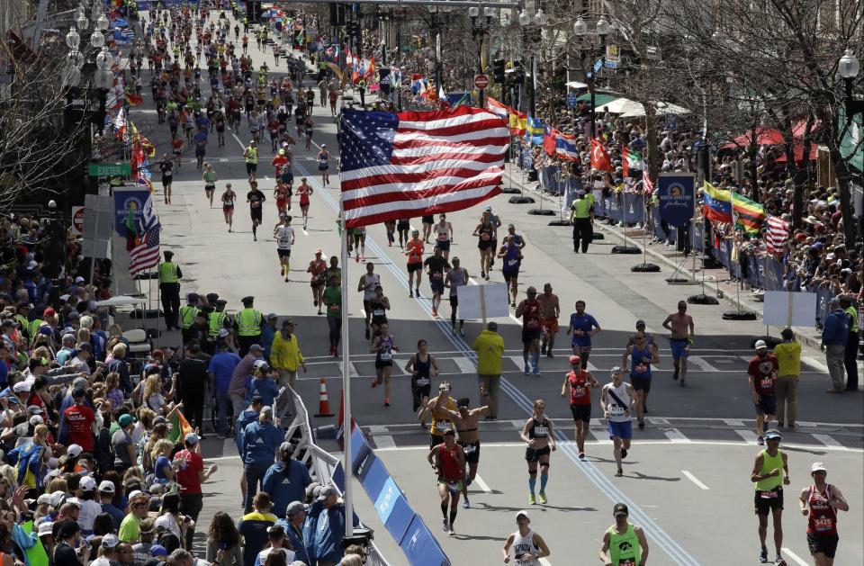 FILE - In this April 17, 2017, file photo, runners head down the stretch to the finish line in the 121st Boston Marathon in Boston. Due to the COVID-19 virus pandemic, the 124th running of the Boston Marathon was postponed from its traditional third Monday in April to Monday, Sept. 14, 2020. (AP Photo/Charles Krupa, File)