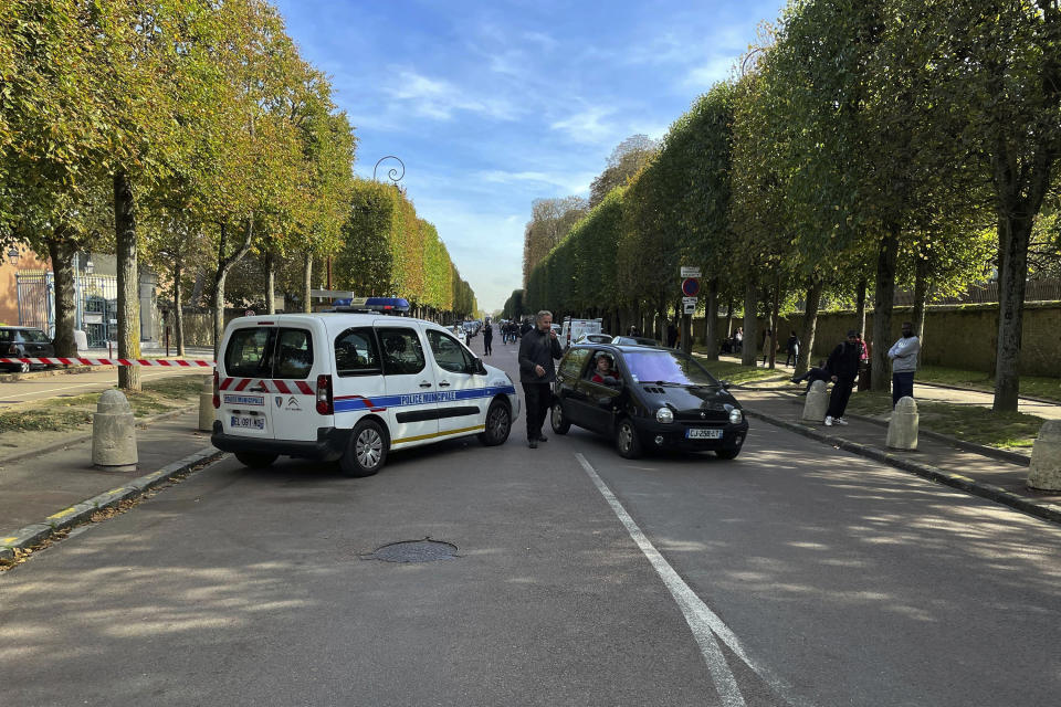 Police escort tourist from the grounds at The Palace of Versailles on Tuesday, Oct. 17, 2023 in Versailles, France. One of France's most visited tourist attractions, was evacuated for a security scare, for the the second time in four days, with France on heightened alert against feared attacks after the fatal stabbing of a school teacher. (AP Photo/Pat Eaton-Robb)