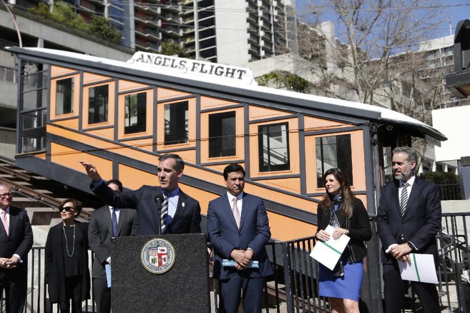 Los Angeles Mayor Eric Garcetti speaks at news conference standing in front of the Angels Flight railway in Los Angeles on Wednesday, March 1, 2017. The tiny funicular that hauled people 298 feet up and down the city's steep Bunker Hill was shut down in 2013 after a series of safety problems. Garcetti said those issues are being resolved and the railroad's antique wooden cars should be back in service by Labor Day. (AP Photo/Nick Ut)