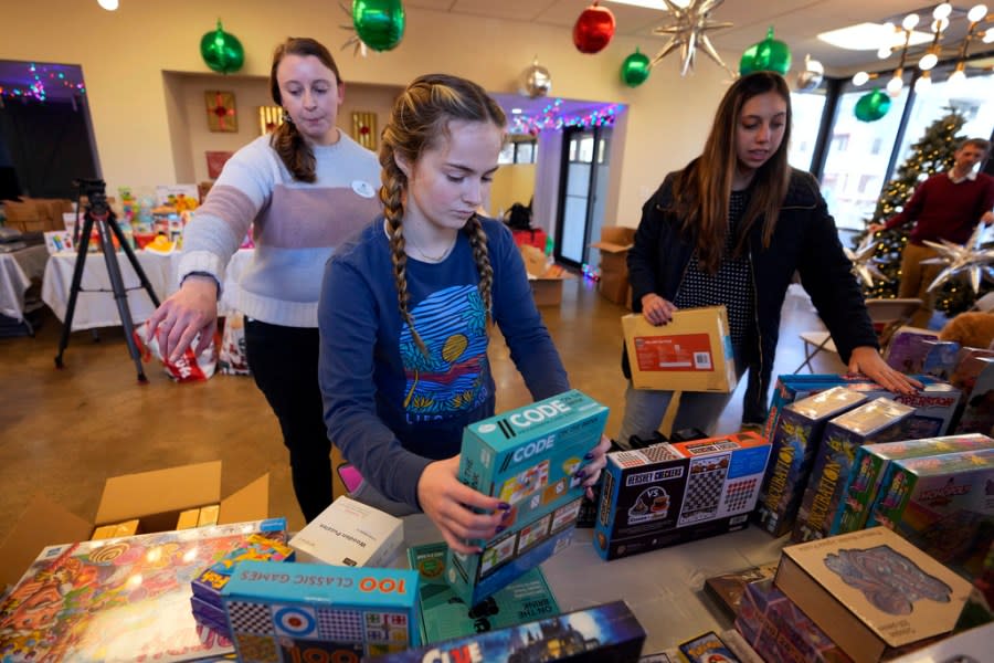 Molly Armbrecht, center, arranges toys at The Toy Store, a free-referral based toy store Thursday, Dec. 7, 2023, in Nashville, Tenn. The facility is co-founded by Brad Paisley and Kimberly Williams-Paisley. The couple also started The Store, a free-referral based grocery store they opened in partnership with Belmont University in March 2020. (AP Photo/Mark Humphrey)