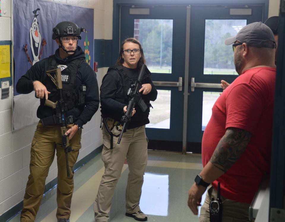 Scott Usry, training director for the Snipers Unknown Training Group, reviews tactics for clearing a wing of the school with Glascock Sheriff Jeremy Kelley and his officers.