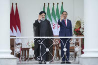 Iran's President Ebrahim Raisi, left, and Indonesian President Joko Widodo wave to journalists during their meeting at the Presidential Palace in Bogor, West Java, Indonesia, Tuesday, May 23, 2023. (AP Photo/Achmad Ibrahim)