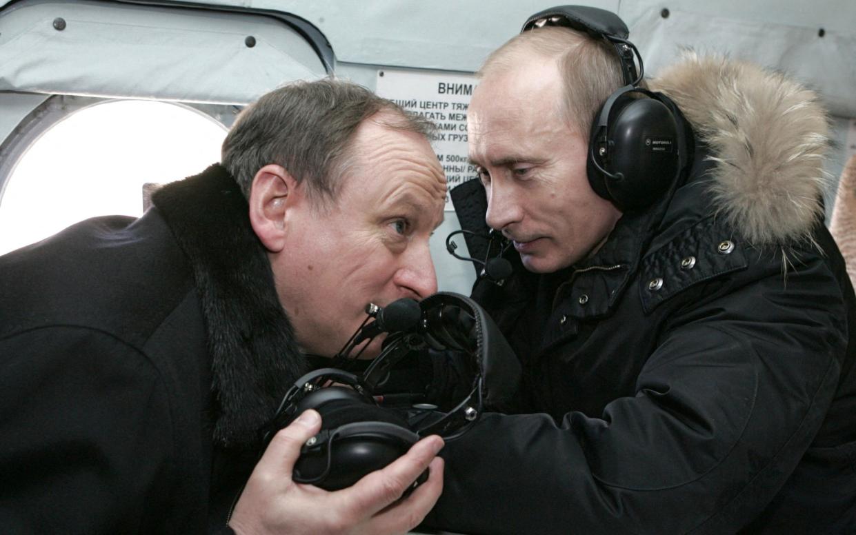 Russian president Vladimir Putin (R) and security services, FSB, chief Nikolai Patrushev fly by helicopter a military base in the turbulent North Caucasus mountains near Chechnya