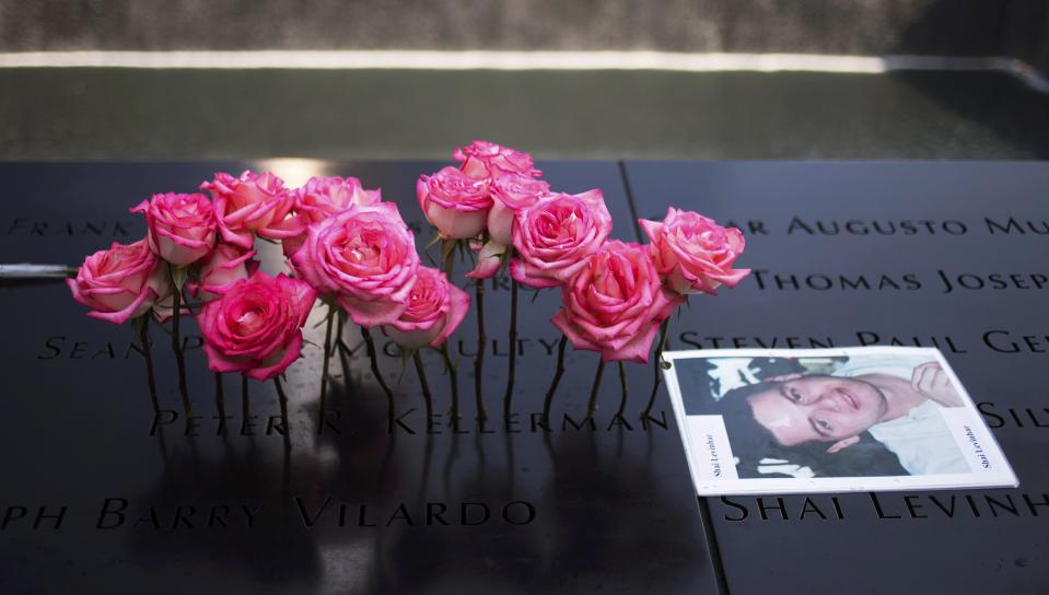 Roses are placed on the inscribed name of Peter Kellerman next to an image of Shai Levinhar along the North Pool during 9/11 Memorial ceremonies marking the 12th anniversary of the 9/11 attacks on the World Trade Center in New York on September 11, 2013. (REUTERS/Adrees Latif)