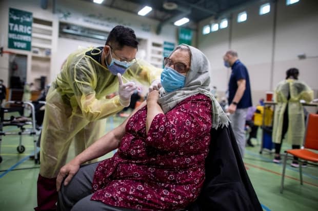 Nurses from Humber River Hospital's mobile vaccine clinic administer COVID-19 vaccines at Toronto and Region Islamic Congregation Centre on April 1. Health Minister Christine Elliott said 3,837,881 COVID-19 vaccine doses have been administered in Ontario as of 8 p.m. on Saturday. (Carlos Osorio/Reuters - image credit)