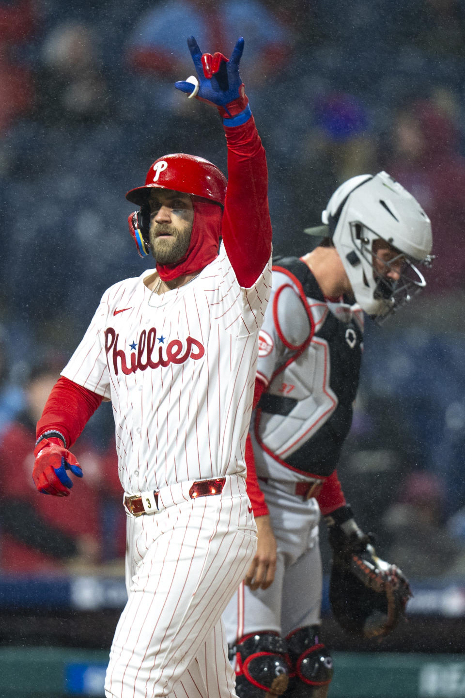 Philadelphia Phillies' Bryce Harper, left, reacts to his home run as Cincinnati Reds catcher Tyler Stephenson, right, looks down during the fourth inning of a baseball game, Tuesday, April 2, 2024, in Philadelphia. (AP Photo/Chris Szagola)