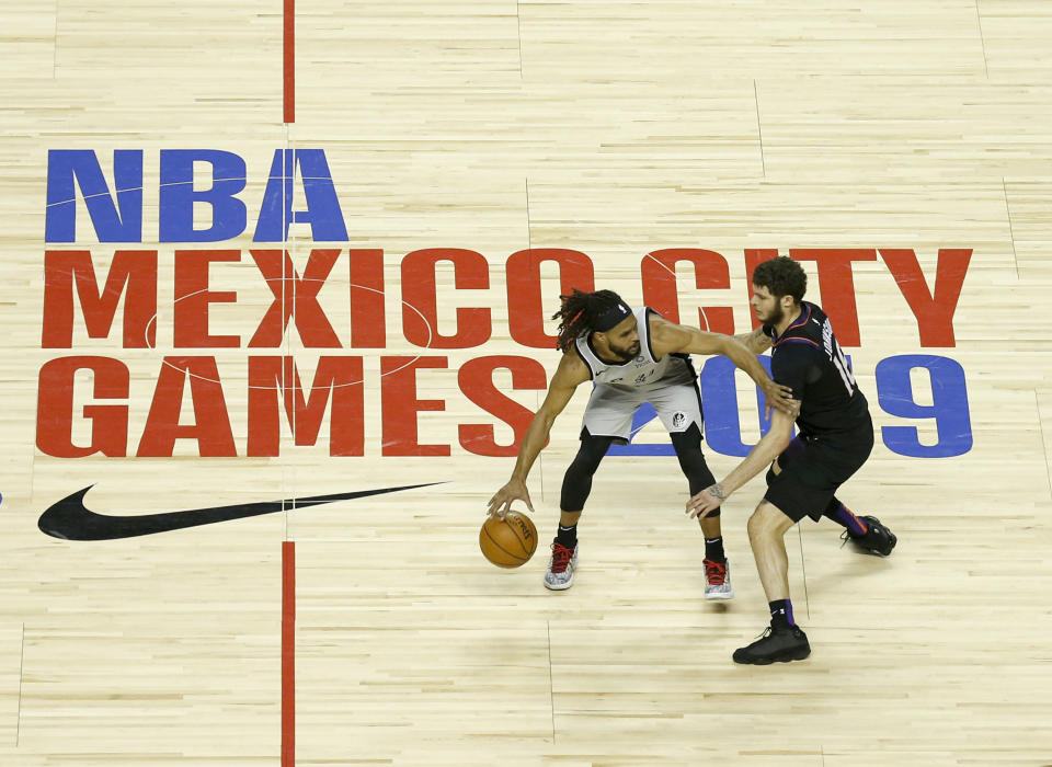 Patty Mills, de los Spurs de San Antonio, intenta driblar a Tyler Johnson, de los Suns de Phoenix en un encuentro disputado el sábado 14 de diciembre de 2019, en la Ciudad de México (AP Foto/Rebecca Blackwell)