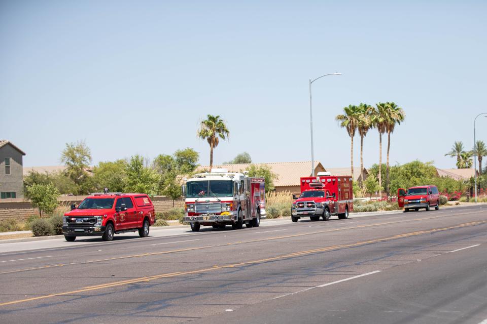 Paramedics and firefighters' vehicles are seen parked outside the scene of an officer-involved shooting near 35th Avenue and Baseline Road in Phoenix on June 14, 2022.
