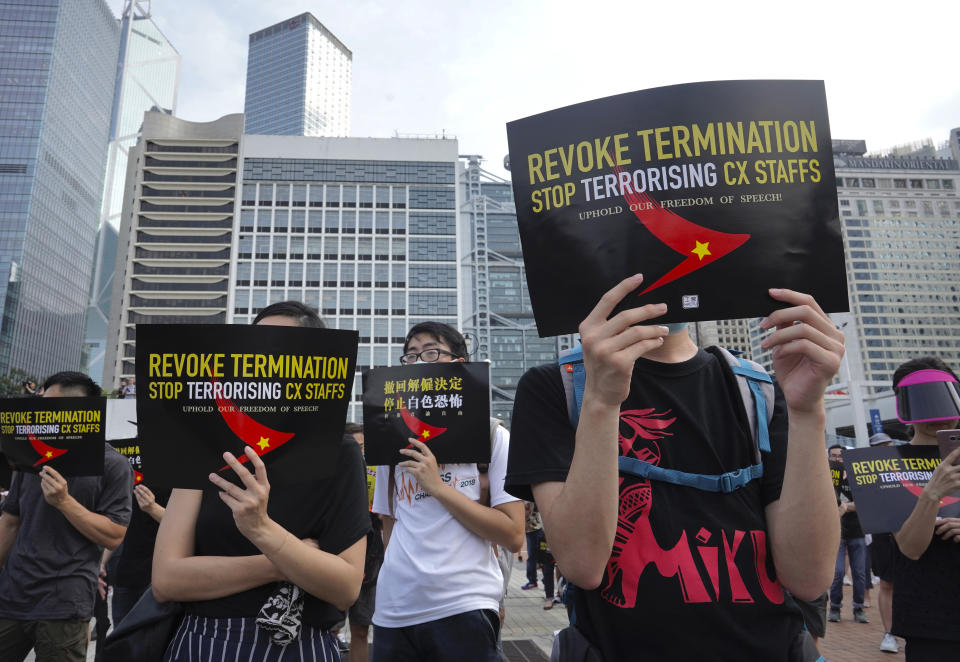 Demonstrators hold signs opposing the recent firings of Cathay Pacific employees as they gather for a demonstration in Hong Kong, Wednesday, Aug. 28, 2019. Trade union members in Hong Kong are rallying against the city's flagship Cathay Pacific airline for firing employees linked to ongoing pro-democracy protests. (AP Photo/Vincent Yu)