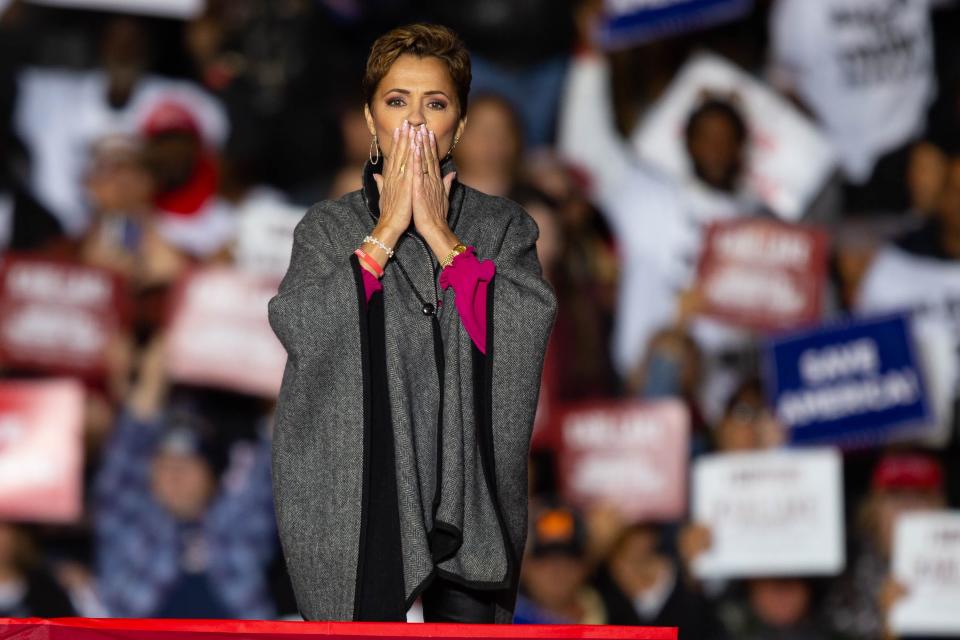 Kari Lake holds her hands to her mouth while leaving the stage ahead of former President Donald Trump's speech in Florence on Saturday, Jan. 15, 2022.