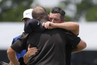 Rory McIlroy, of Northern Ireland, facing, congratulates teammate Shane Lowry, of Ireland, after finishing the day on the ninth green during the second round of the PGA Zurich Classic golf tournament at TPC Louisiana in Avondale, La., Friday, April 26, 2024. (AP Photo/Gerald Herbert)