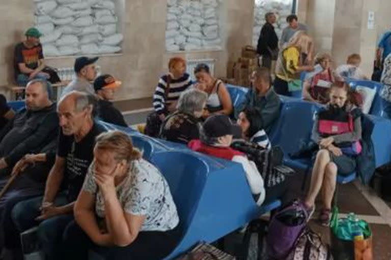 Los residentes locales esperan un tren de evacuación en una estación de Jersón