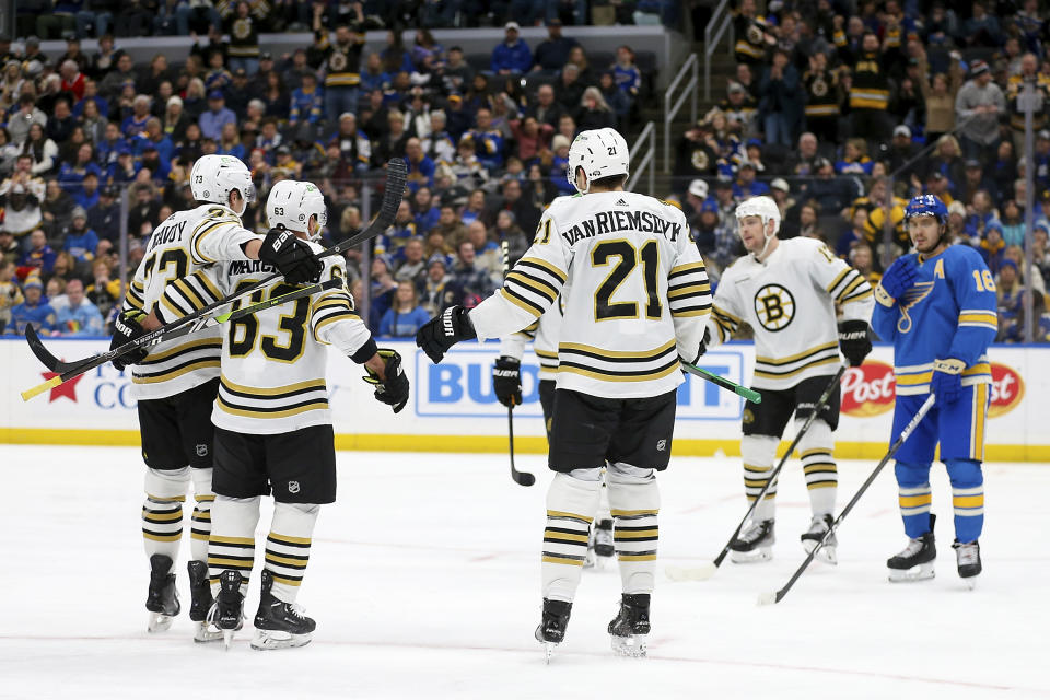 Boston Bruins' Brad Marchand, second from left, is congratulated by teammates after scoring his second goal of the night, during the third period of the team's NHL hockey game against the St. Louis Blues on Saturday, Jan. 13, 2023, in St. Louis. (AP Photo/Scott Kane)