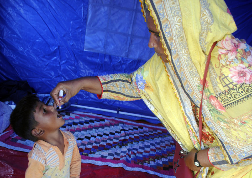 A health worker administers a polio vaccine to a child at a camp in Hyderabad, Pakistan, Tuesday, Sept. 6, 2022. In flood-stricken Pakistan where an unprecedented monsoon season has already killed hundreds of people, the rains are now threatening an ancient archeological site dating back 4,500 years, the site's chief official said Tuesday. (AP Photo/Pervez Masih)