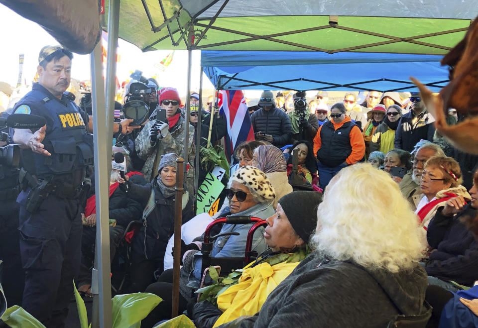 FILE - In this July 17, 2019, file photo, officers from the Hawaii Department of Land and Natural Resources prepare to arrest protesters, many of them elderly, who are blocking a road to prevent construction of a giant telescope on a mountain that some Native Hawaiians consider sacred, on Mauna Kea on the Big Island of Hawaii. Native Hawaiians whose protests stopped one of the world's most advanced telescopes from being built in Hawaii are objecting to President Joe Biden's choice for U.S. attorney in the 50th state. They say Clare Connors, as state attorney general, treated dozens of elders who who were practicing their constitutionally protected right to protest as criminals when her office prosecuted them for blocking a road to the construction site on the state's tallest mountain.(Cindy Ellen Russell/Honolulu Star-Advertiser via AP, File)