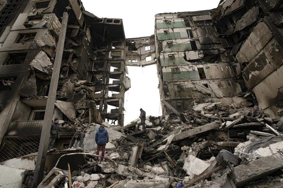 Residents look for belongings in the ruins of an apartment building destroyed during fighting between Ukrainian and Russian forces in Borodyanka, Ukraine, Tuesday, April 5, 2022. Ukrainian President Volodymyr Zelenskyy accused Russian troops of gruesome atrocities in Ukraine and told the U.N. Security Council on Tuesday that those responsible should immediately be brought up on war crimes charges in front of a tribunal like the one set up at Nuremberg after World War II.(AP Photo/Vadim Ghirda)