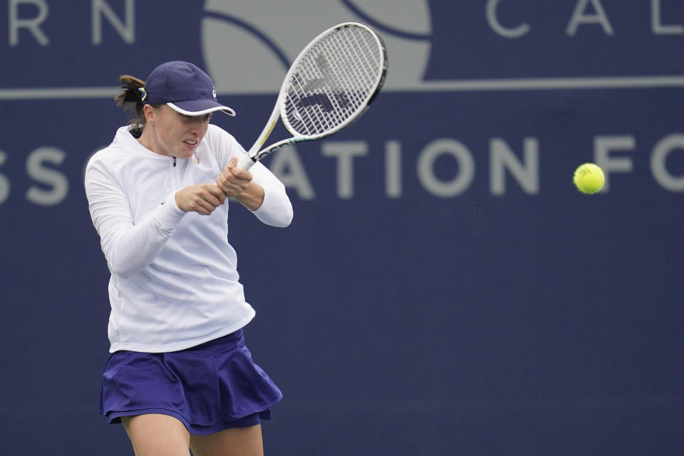 Iga Swiatek of Poland returns to Qinwen Zheng of China at the San Diego Open tennis tournament Thursday, Oct. 13, 2022, in San Diego. (AP Photo/Gregory Bull)