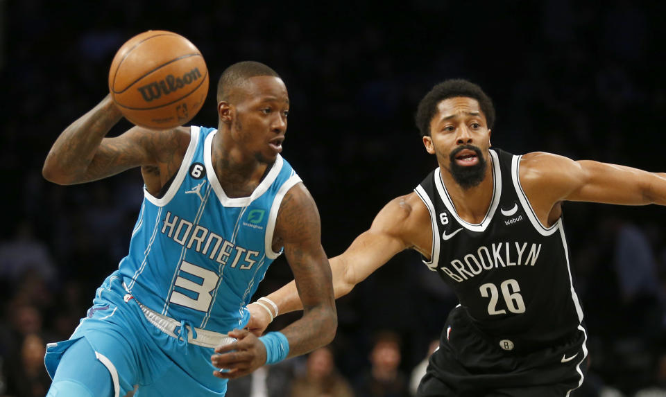 Charlotte Hornets guard Terry Rozier (3) dribbles around Brooklyn Nets guard Spencer Dinwiddie (26) during the first half of an NBA basketball game, Sunday, March 5, 2023, in New York. (AP Photo/John Munson)