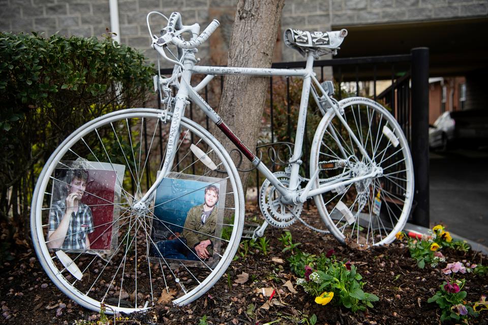 A “Ghost Bike” was chained to a tree along Grove Street in Downtown Asheville where James Shearon was killed while riding his bicycle in a hit-and-run.