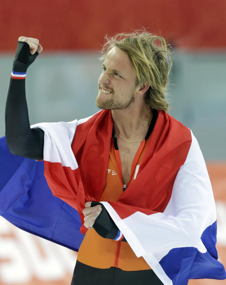 Michel Mulder from the Netherlands holds his national flag and celebrates winning gold in the men's 500-meter speedskating race at the Adler Arena Skating Center during the 2014 Winter Olympics, Monday, Feb. 10, 2014, in Sochi, Russia. (AP Photo/Matt Dunham)