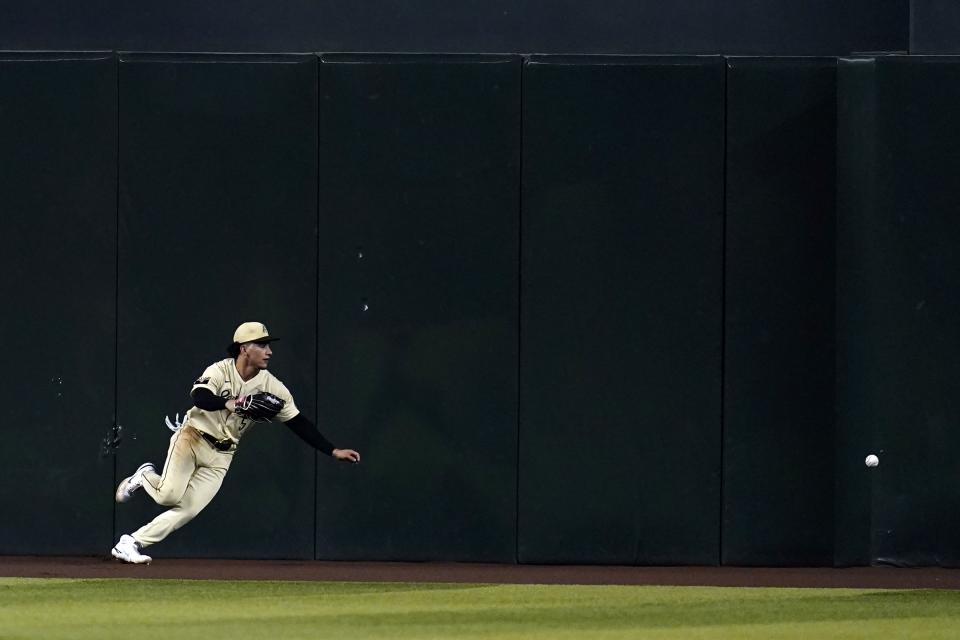Arizona Diamondbacks center fielder Alek Thomas is unable to make a play on a double hit by Colorado Rockies' Elias Diaz during the fourth inning of a baseball game Friday, Aug. 5, 2022, in Phoenix. (AP Photo/Ross D. Franklin)