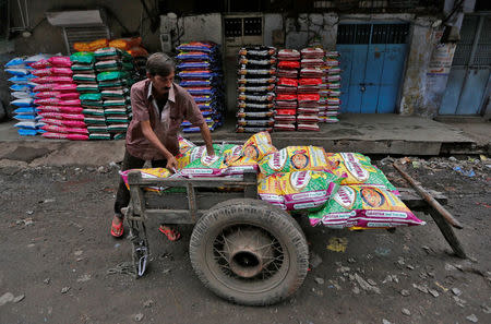 A worker loads bags of pulses onto a hand cart at a wholesale market in Ahmedabad, India August 31, 2016. REUTERS/Amit Dave