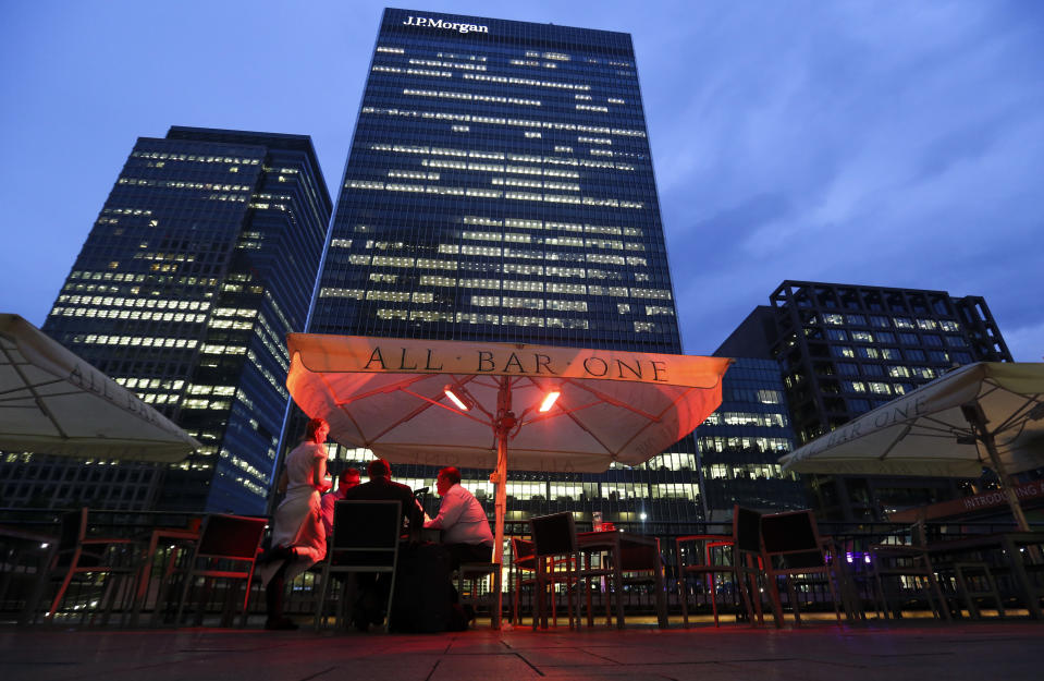 A waitress, left, serves customers as they sit outside an All Bar One bar, operated by Mitchells & Butlers Plc, near the offices of JPMorgan Chase & Co. in the Canary Wharf business, finance and shopping district. Photo: Chris Ratcliffe/Bloomberg via Getty Images