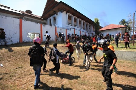 Protesters are seen outside the local parliament building during a protest in Kendari