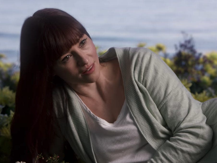 Lexie with long hair and bangs in the flowers on the beach on Greys Anatomy