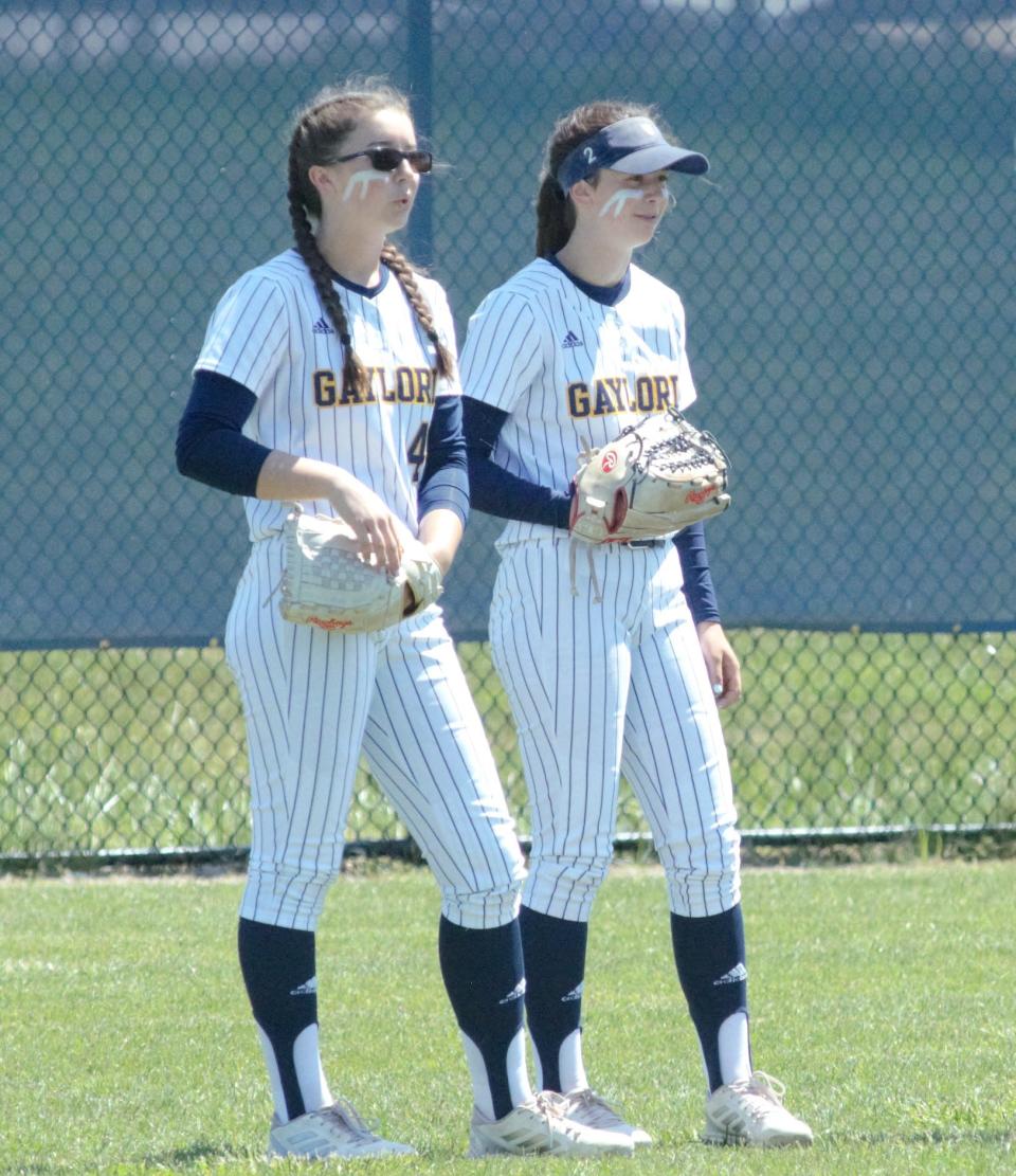 Addison Wangler (left) and Kennedy Wangler (right) watch as their team warms up prior to the 2022 district semifinal matchup with Gladwin.