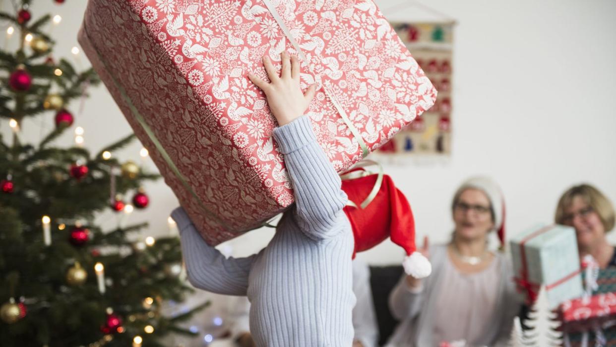 Little boy carrying big cardboard box during Christmas