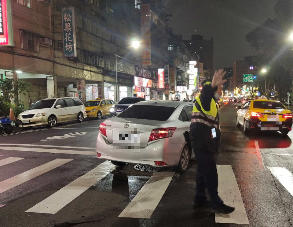 三重警分局厚德派出所警員周元國、施韋晴，協助拋錨自小客車主，聯手推車10公尺，將拋錨車輛推至較寬的路邊，才紓解阻塞的車流。（三重警分局提供）