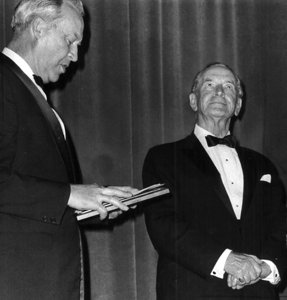 Roger Guiles (left), president of University of Wisconsin-Oshkosh, presented a bronze plaque to actor Fredric March in 1971. The plaque included March's name, which was placed in the university's Fredric March Theater until its removal in 2020.