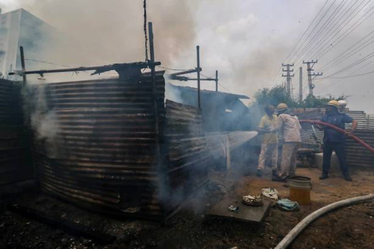 Firefighters douse a fire suspectedly an arson in Manesar on 2 August 2023, following communal clashes in India’s Haryana state (AFP via Getty Images)