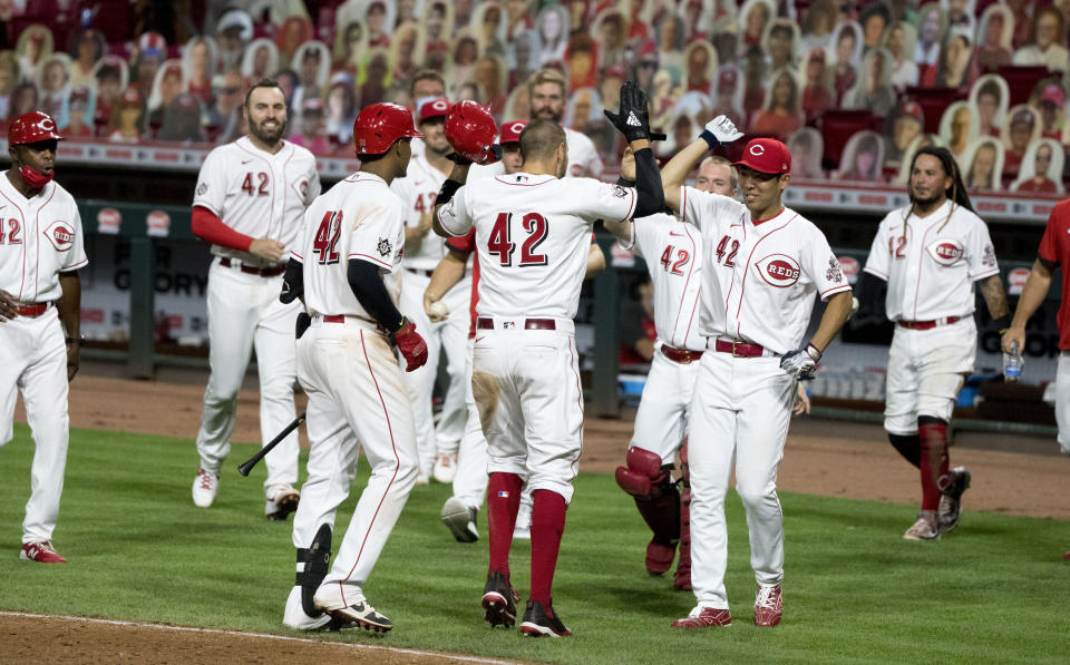 Nick Castellanos, de los Rojos de Cincinnati, festeja luego de anotar la carrera del triunfo sobre los Cachorros de Chicago, el sábado 29 de agosto de 2020, en el segundo duelo de una doble cartelera (Albert Cseare/The Cincinnati Enquirer via AP)